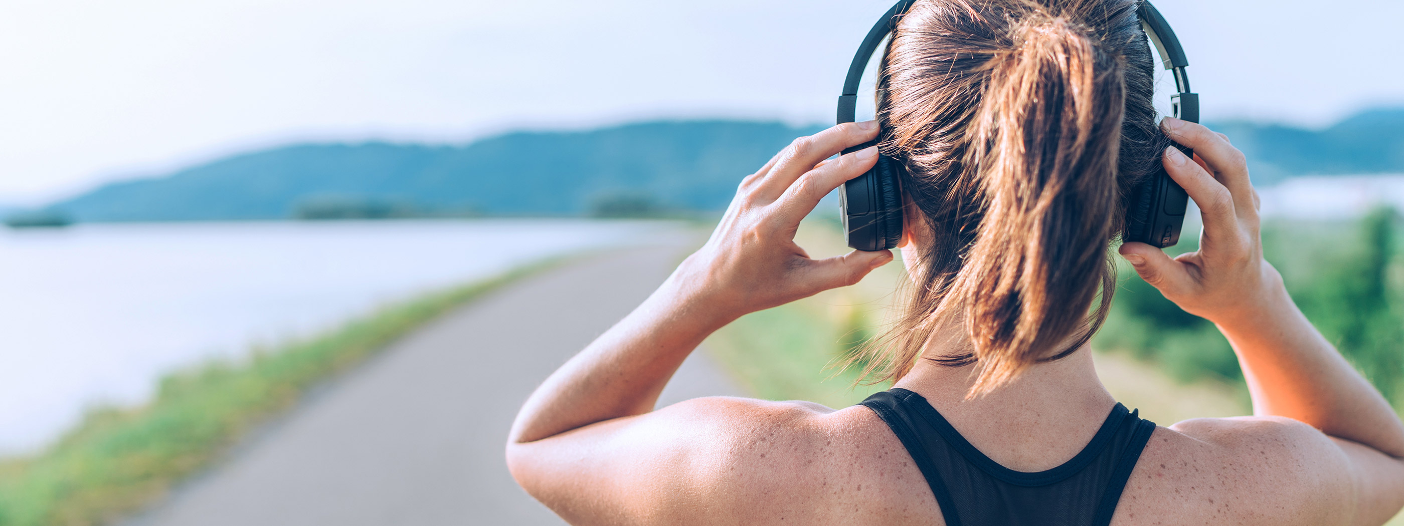 Gesundheit ermöglichen - der Podcast der apoBank Frau hört Podcast im Freien