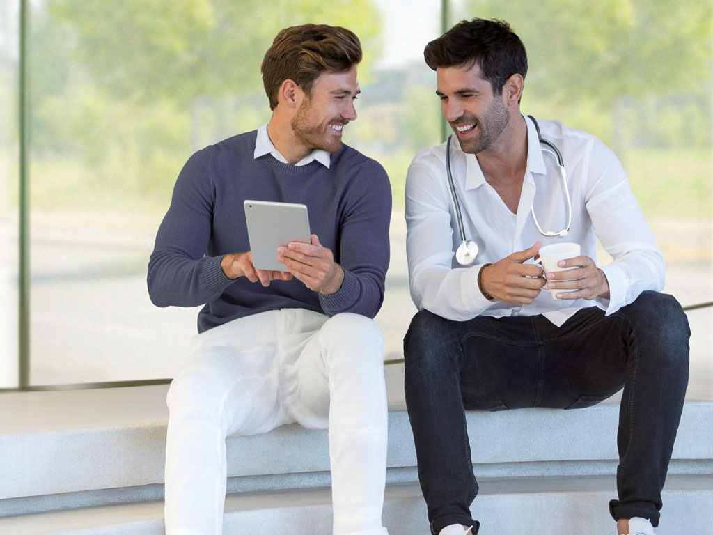 Foto: Zwei Männer schauen auf ein Tablet. Kunden werben Kunden. Begeisterung ist ansteckend