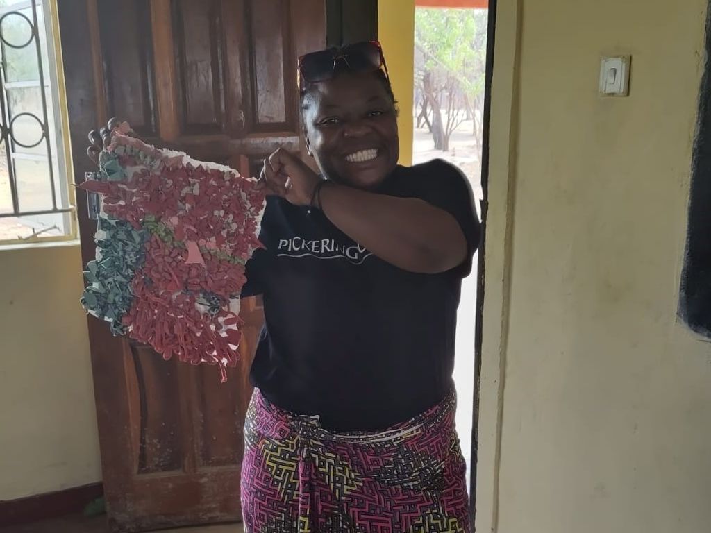apoBank-Stiftung unterstuetzt Schule in Sambia Junge Frau mit selbst gemachtem Teppich