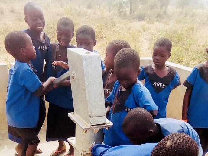Kinder in Afrika freuen sich ueber den Brunnen, dessen Bau die apoBank-Stiftung unterstuetzt hat
