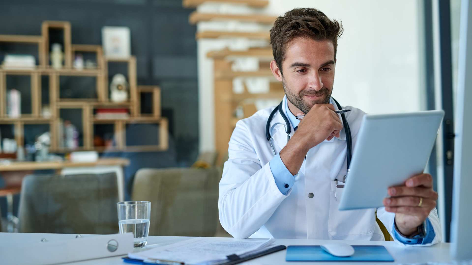 digas faq arzt schaut sich applikation an Arzt studiert am Schreibtische Digitale Gesundheitsanwendungen