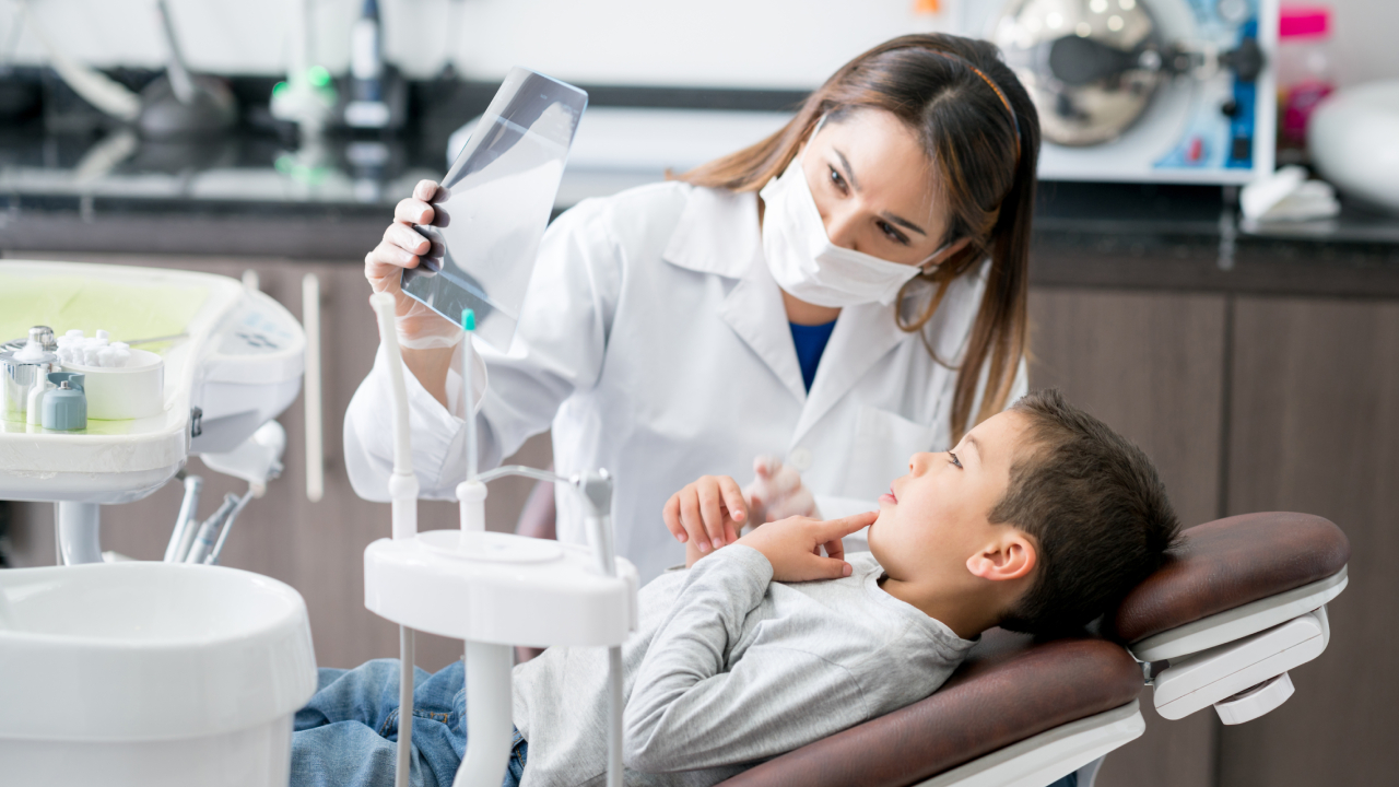 Zahnarzt Gehalt: Zahnärztin erklärt Kind ein Röntgenbild