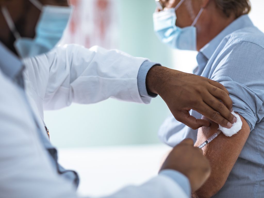 Impfen in der Arztpraxis: Patient wird gegen Corona geimpft